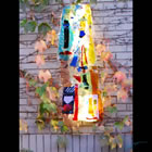 Lighted float-mounted kiln-formed glass sculpture on an outdoor fireplace